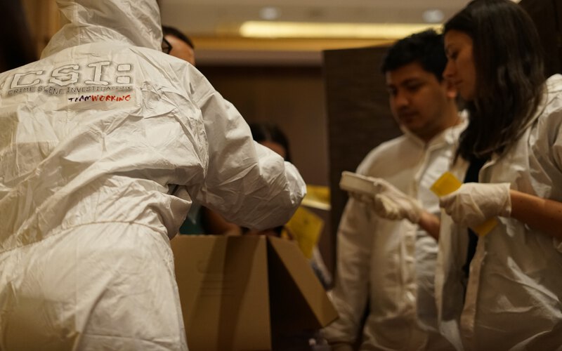 A participant in a forensic suit examining the evidence at the scene
