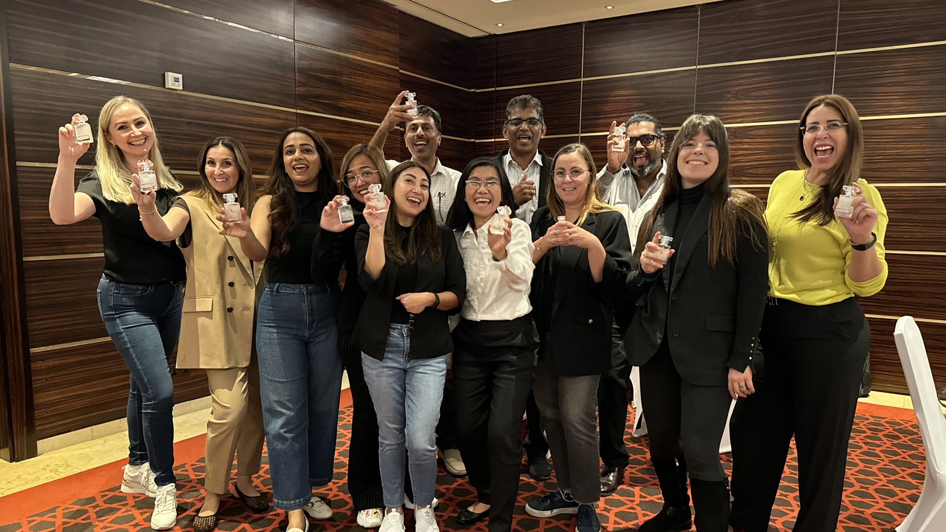 A team holding up the perfumes they created together
