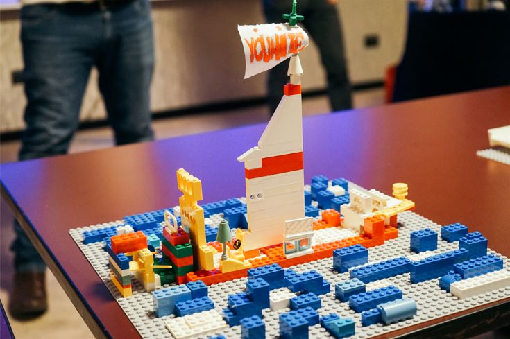A team building a three-dimensional model out of Lego bricks