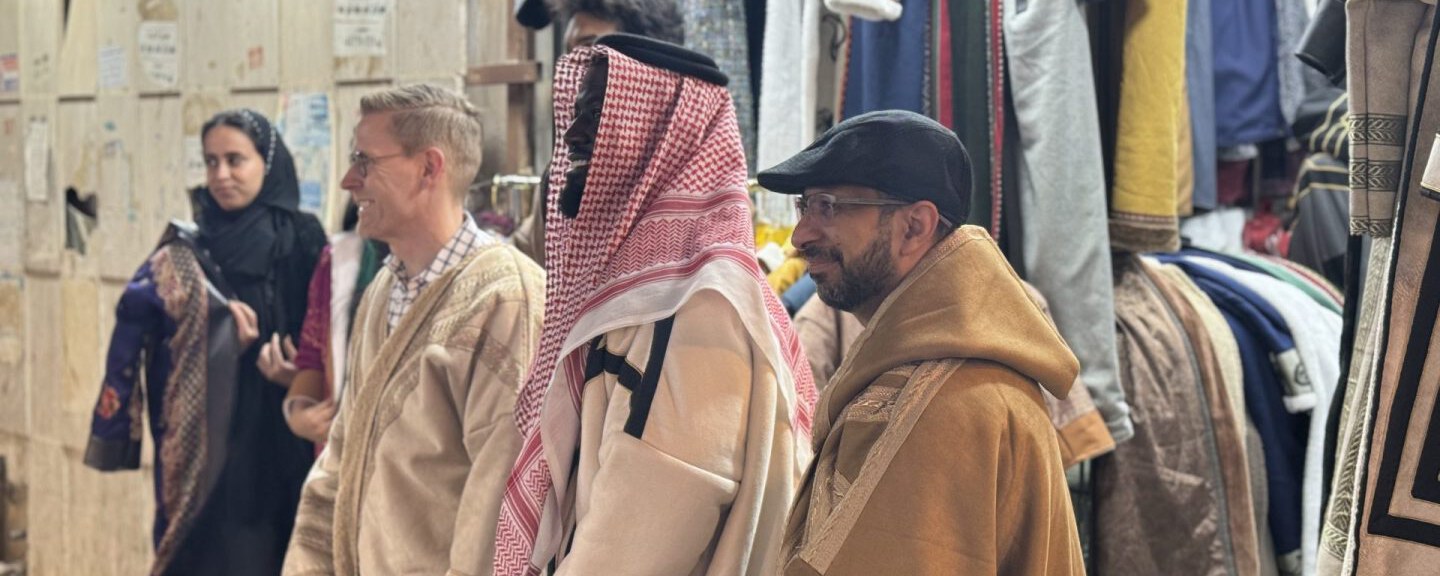 A team listening to a local guide in the souk