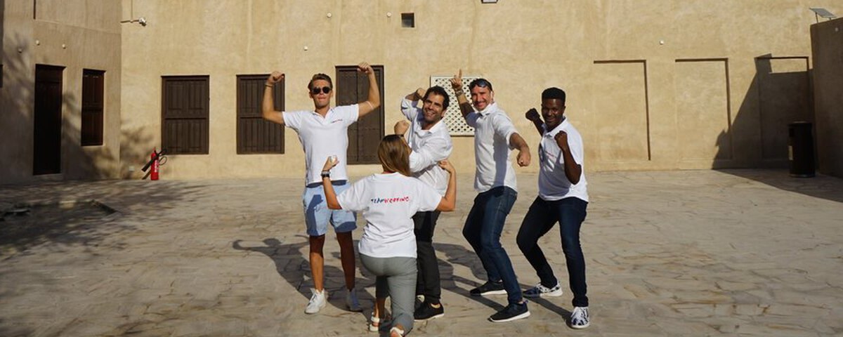 A team striking a pose in the old quarter of Al Fahidi